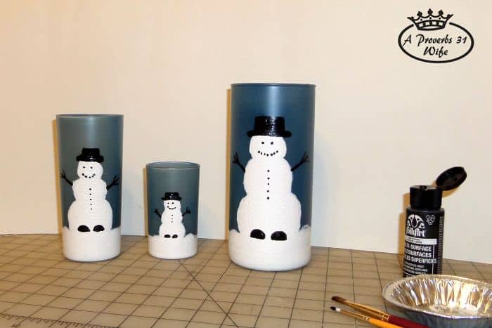 Painted snowmen with eyes, arms, hat, and buttons