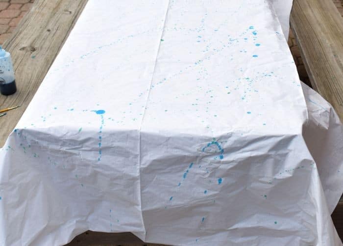 Use tie dye and paint brushes to make a tie dye tablecloth with the splatter technique