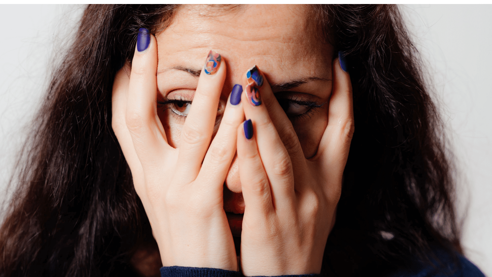 Woman covers his face by hand