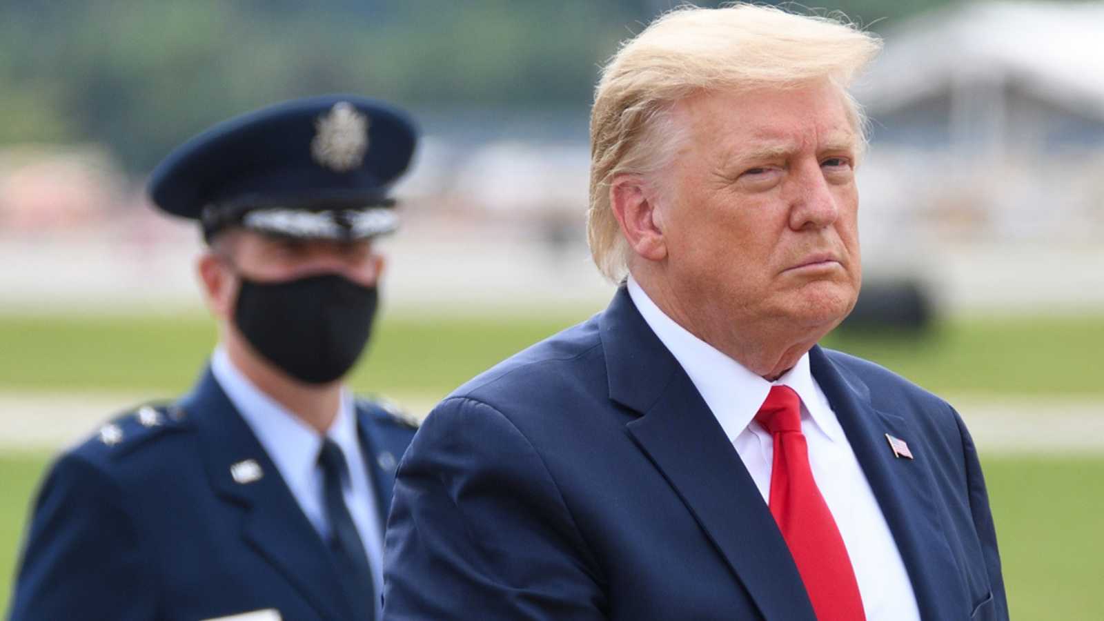 MARIETTA, GA- SEPTEMBER 25, 2020: President Donald Trump walks to "The Beast" limousine with Air Force Major General John P. Healy in the background wearing a face mask at Dobbins Air Reserve Base.