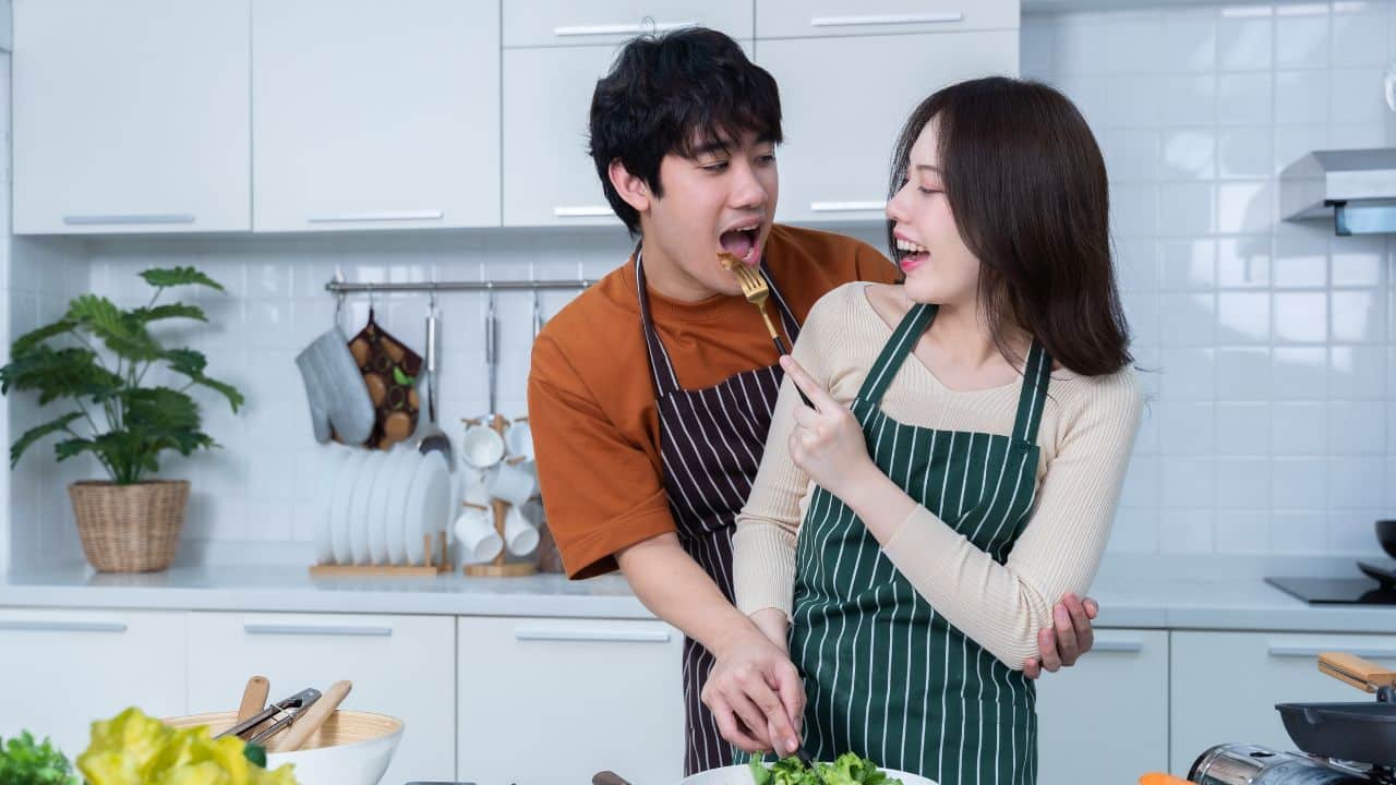 man who was tasting the food his girlfriend made preparing beef steak food