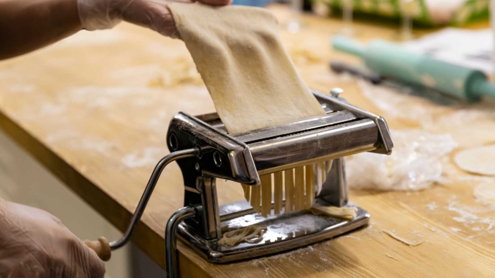 Cooking home made pasta with italian pasta maker: pastry, wheat flour on wood