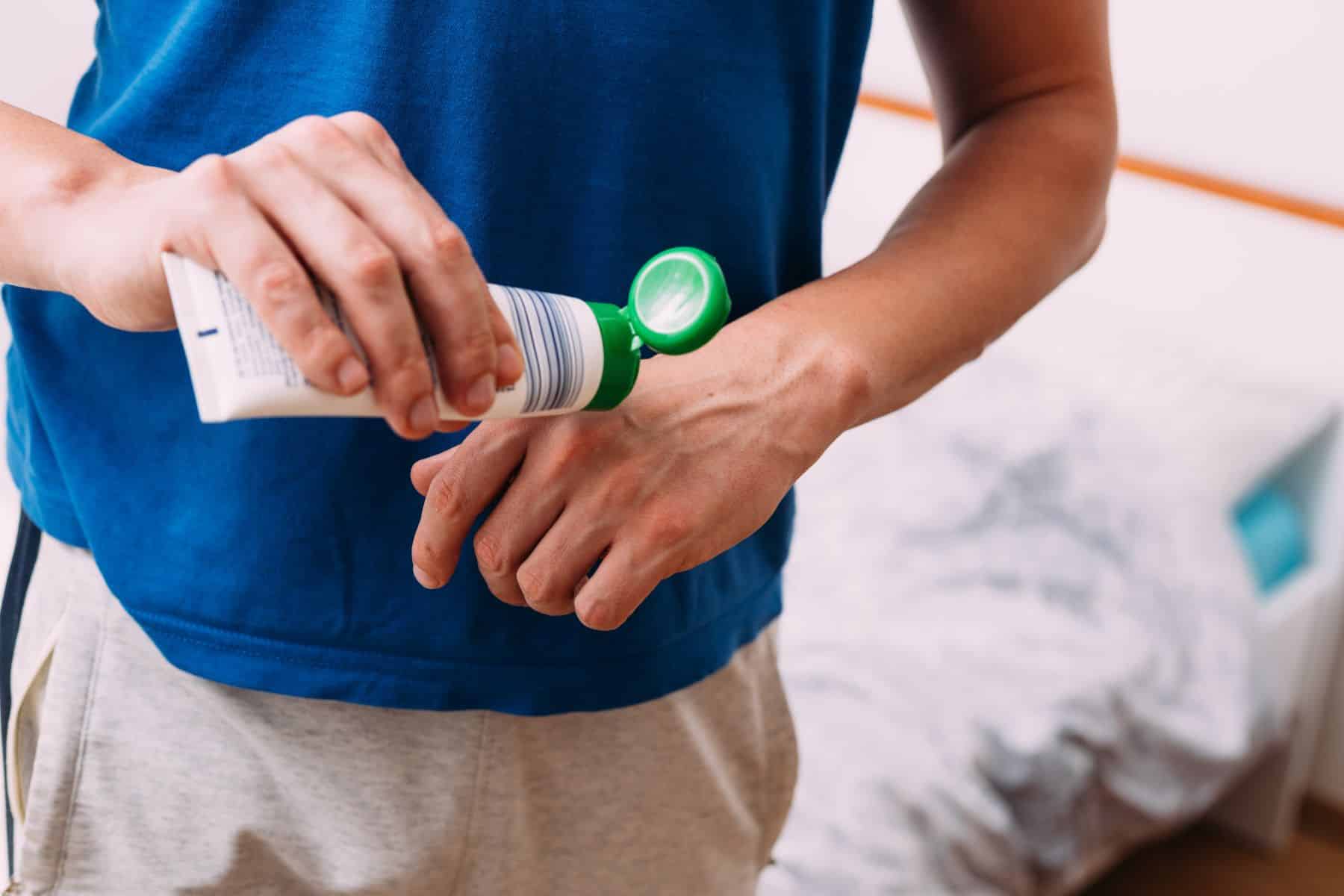 Close up shot of a man applying hand cream in bedroom