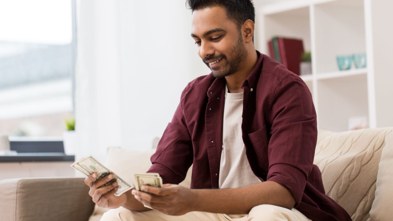 man counting cash at home
